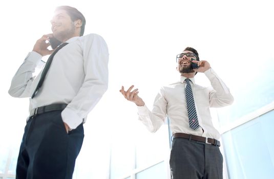 bottom view.business people talking on their mobile phone in the office.the concept of communication