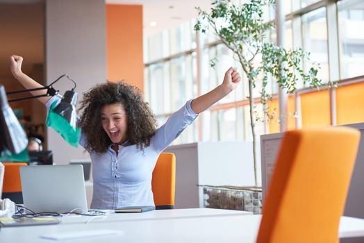 happy young  business woman with curly hairstyle in the modern office