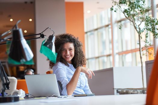 happy young  business woman with curly hairstyle in the modern office