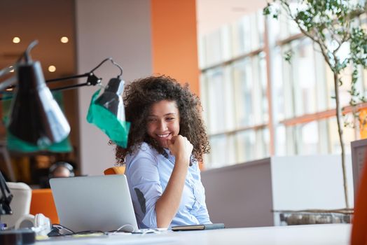 happy young  business woman with curly hairstyle in the modern office