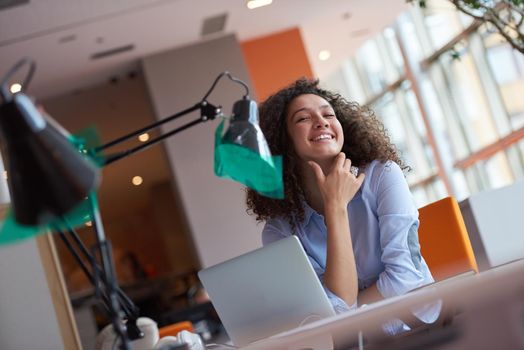 happy young  business woman with curly hairstyle in the modern office