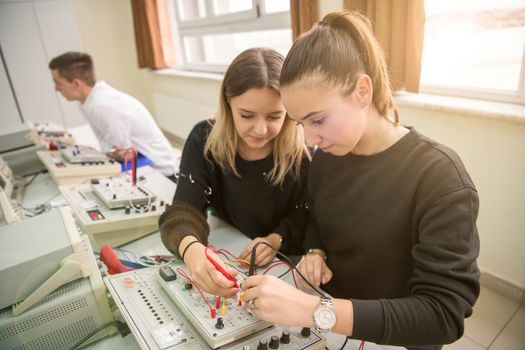 Group of young students doing technical vocational practice with teacher in the electronic classroom, Education and technology concept