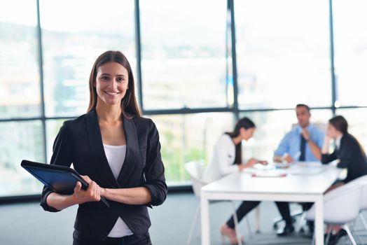 happy young business woman  with her staff,  people group in background at modern bright office indoors