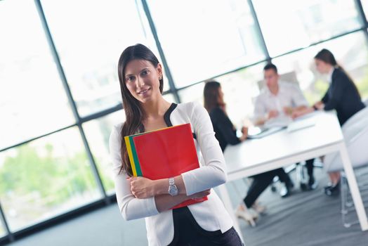 happy young business woman  with her staff,  people group in background at modern bright office indoors