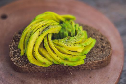 Avocado sandwich on dark rye bread made with fresh sliced avocados.