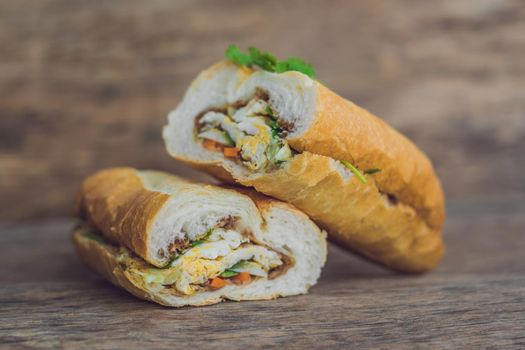 A delicious Vietnamese Bahn Mi sandwich on a wooden background.