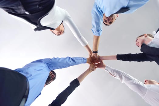 business people group joining hands and representing concept of friendship and teamwork,  low angle view