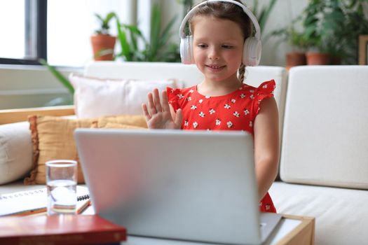 Little girl studing online with video call teacher. Distance learning