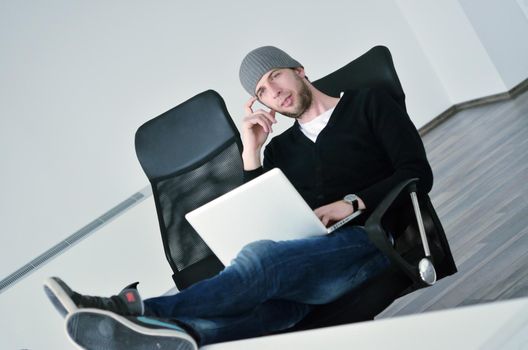 casual young business man relax and work on laptop computer with foots on table