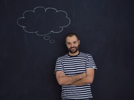 young future father thinking about names for his unborn baby to writing them on a black chalkboard