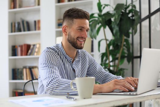 Happy young business man is analizing financial documents from home during self isolation