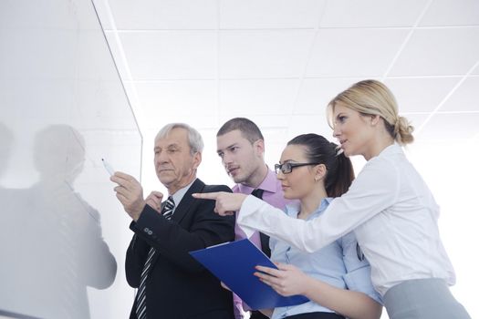 Senior male business man giving a presentation at a  meeting at modern light office on a table board