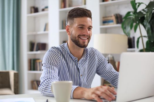 Happy young business man is analizing financial documents from home during self isolation