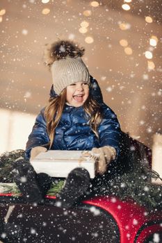 Picture of cute little girl in a warm clother and have a lot of fun under the snow
