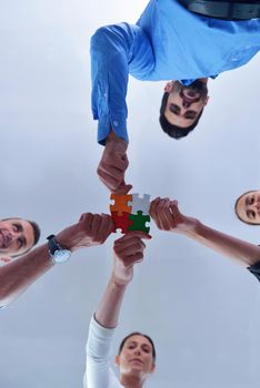 Group of business people assembling jigsaw puzzle and represent team support and help concept