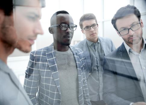 behind the glass. a group of business people in the office.the concept of teamwork