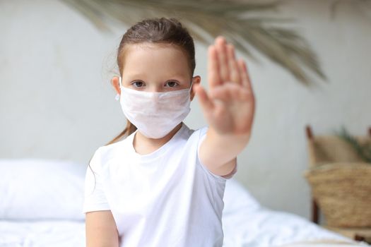 Little girl in medical masks showing Stop of COVID-19 epidemic