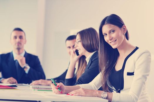 happy young business woman  with her staff,  people group in background at modern bright office indoors