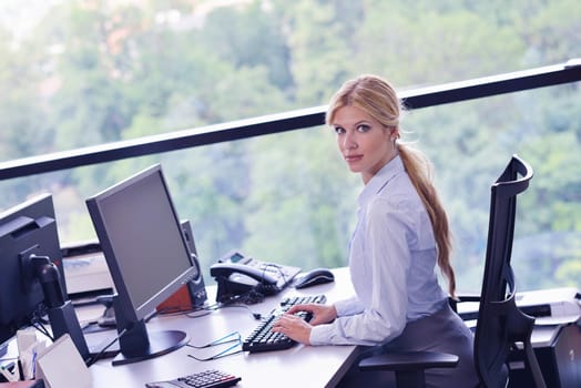 Portrait of a beautiful business woman working on her desk in an office environment.