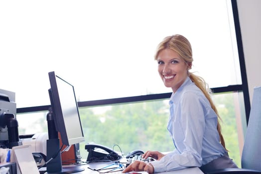 Portrait of a beautiful business woman working on her desk in an office environment.