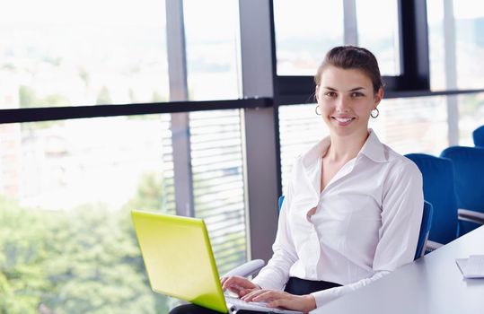 Young pretty business woman with notebook in the bright modern office indoors