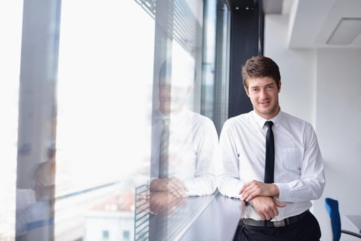 Portrait of a handsome young  business man  on a meeting in offce with colleagues in background