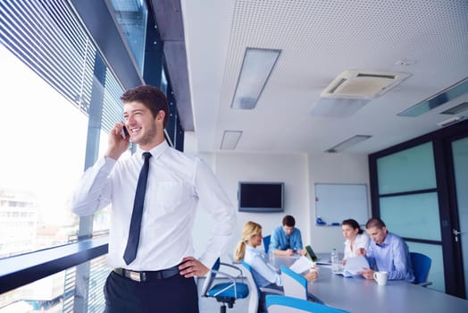 Portrait of a handsome young  business man  on a meeting in offce with colleagues in background