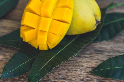 Mango and mango leaves on an old wooden background.