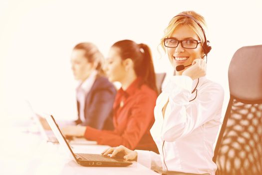 Pretty young business woman group with headphones smiling at you against white background