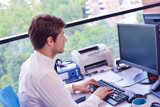 happy young business  man work in modern office on computer