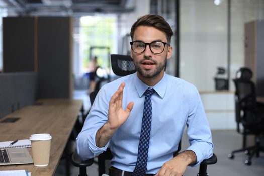 Confident businessman looking at camera talking about company strategy and business plan, explaining corporate success