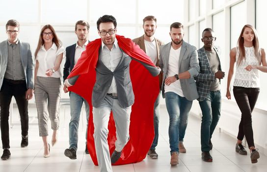 businessman in a red cloak heads the business team. goal concept