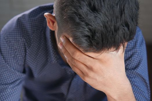 Depressed man feeling sick and worried about financial problem.