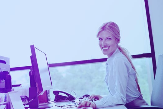 Portrait of a beautiful business woman working on her desk in an office environment.