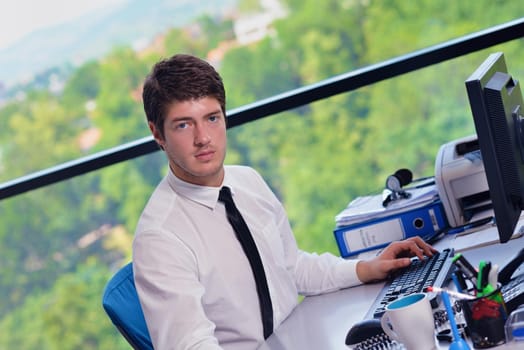 happy young business  man work in modern office on computer