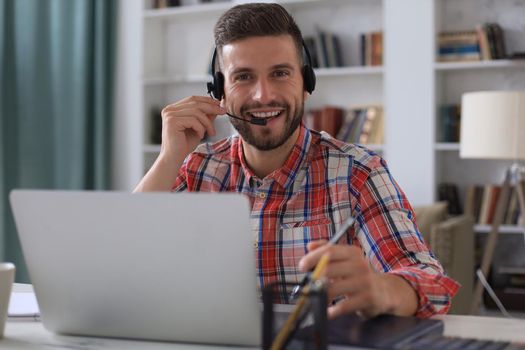 Smiling young business man having video call at home office