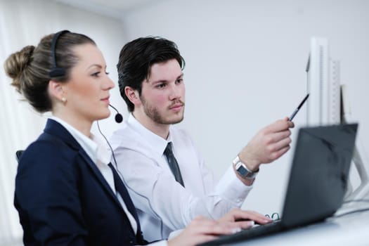 business people group with  headphones giving support in  help desk office to customers, manager giving training and education instructions