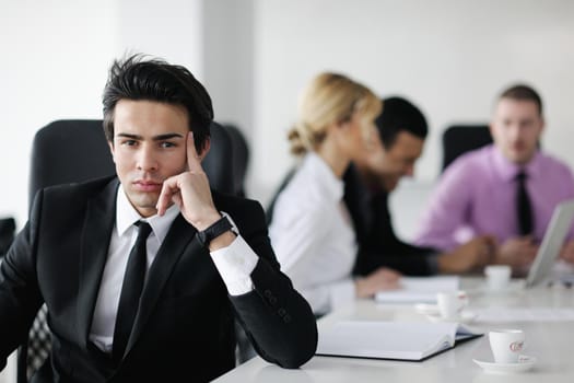 Confident young business man attending a meeting with his colleagues