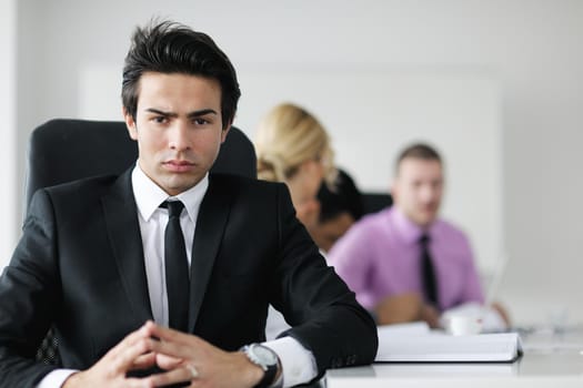 Confident young business man attending a meeting with his colleagues