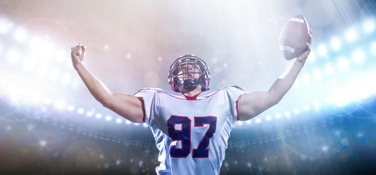 american football player celebrating after scoring a touchdown on big modern stadium field with lights and flares at night