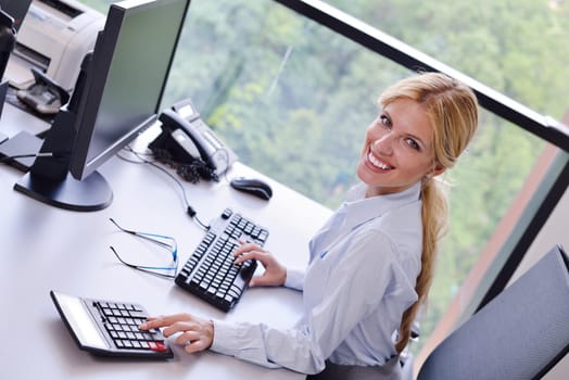 Portrait of a beautiful business woman working on her desk in an office environment.