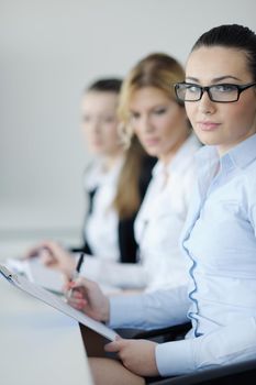 Successful business woman standing with her staff in background at modern bright office