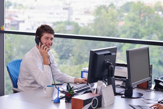 happy young business  man work in modern office on computer