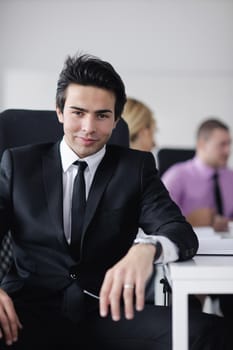 Confident young business man attending a meeting with his colleagues