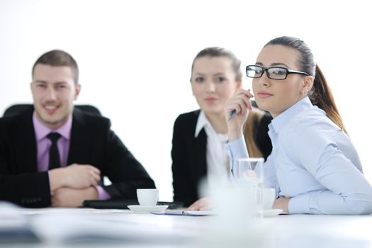 Successful business woman standing with her staff in background at modern bright office