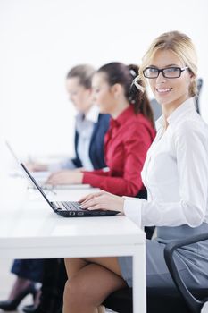 Pretty young business woman group with headphones smiling at you against white background