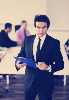 Confident young business man attending a meeting with his colleagues