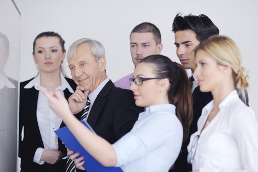 Senior male business man giving a presentation at a  meeting at modern light office on a table board