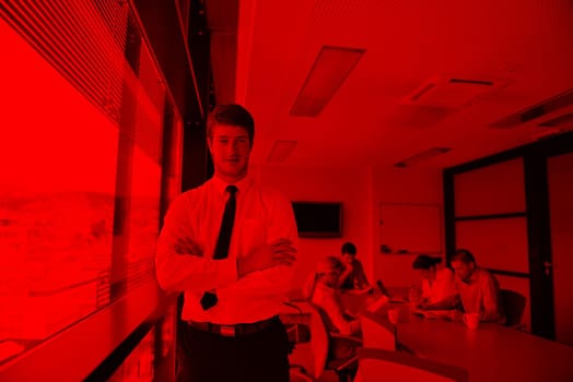 Portrait of a handsome young  business man  on a meeting in offce with colleagues in background