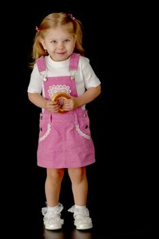 Beautiful little girl, studio portrait on a black background. The concept of a happy childhood, style and fashion.